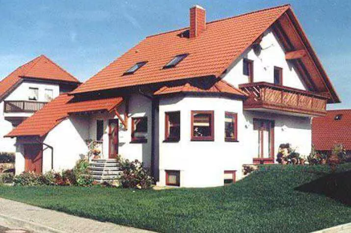 Landhaus mit Putzfassade und Holzfenstern / Holzbalkon - eher typisch für den bayerischen Raum